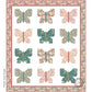 A digital image of a lap quilt with butterfly patterns in floral pinks and greens on a white background with a decorative floral border.