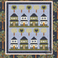 Front cover of lap quilt pattern that has 8 quaint houses sitting on lines of green grass with lollipop like tree blocks, half of which have blue hearts in them. The remaining trees have a floral pattern. The houses and trees are set on a blue background with a darker blue border. The  quilt patterns is titled 'Family Neighborhood' by Coach House Designs. 