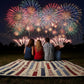 Family sitting on the Fireworks lap quilt which is  made from Deb Strain's America 250  Years fabric Jelly Roll.  The blocks represent the bursts with stars and rectangular blocks for the trails.