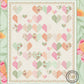 'Kind Hearts' lap quilt pattern by Coach House Designs is a filled with pastel colored heart blocks. Each heart is made of complimentary colors in soft hues of pink, greens, peach and orange on a cream color background. 
